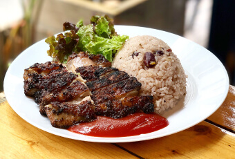 炭火で焼き上げたこんがりジューシーな「ジャークチキン」と豆と一緒に炊き上げたご飯の盛り付け