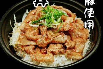 大麦仕上三元豚使用した炭火焼き豚丼。白ご飯の上にキャベツの千切りと炭火焼きでタレを纏った豚肉が載っています