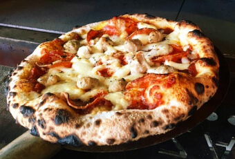 アツアツのピザが楽しめる石窯を積んだフードトラック。自慢の3種のブレンドチーズとコク、旨味が絶妙なバランスのピザ