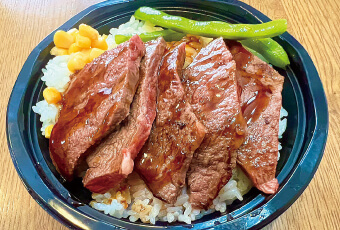 ソースを絡めたジューシーなステーキが4枚といんげん、コーンが載ったボリュームのあるステーキ丼